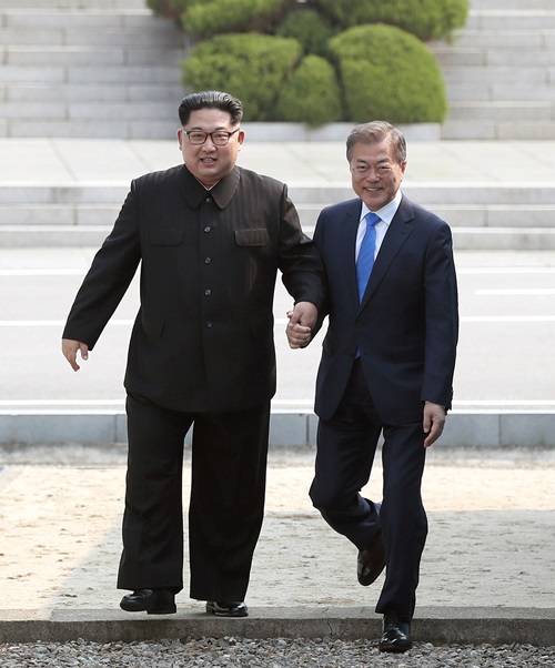 문재인 대통령(오른쪽)과 김정은 북한 국무위원장이 4월 27일 첫 정상회담을 앞두고 판문점에서 손을 맞잡고 군사분계선을 함께 넘고 있다. 사진공동취재단