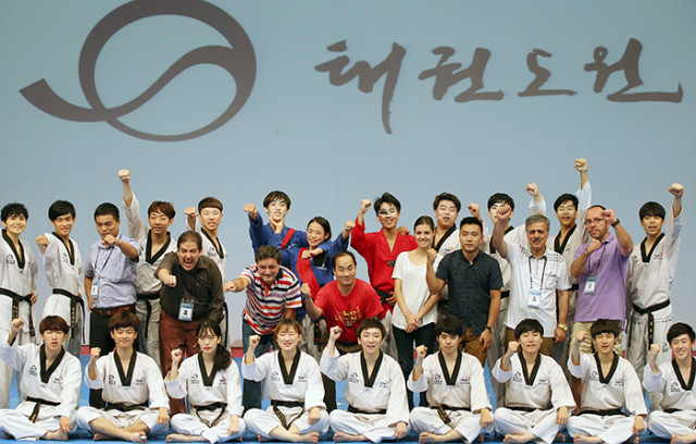 21日，访问跆拳道园的外国记者团与跆拳道示范团合影留念。