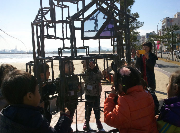 학생들이 포항 도심에 전시된 철로 만든 설치작품에 대한 설명을 듣고 있다.