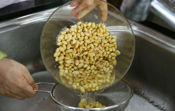흰 콩은 깨끗이 씻은 뒤 잘 손질해서 물에 8시간 정도 불린 뒤 체에 밭쳐 물기를 뺀다. 