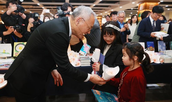 迎接“世界读书日”韩文体部长官柳仁村向市民赠送图书