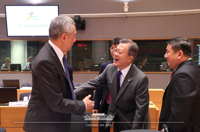 当地时间10月19日，韩国总统文在寅出席在比利时布鲁塞尔举行的第十二届亚欧首脑会议，与新加坡总理李显龙会面。