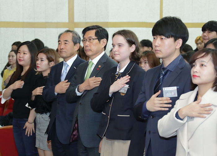 서울시 거주 귀화 허가자들이 21일 서울 용산구 국립한글박물관에서 열린 ‘제1회 대한민국 국적증서 수여식’에서 박상기 법무부 장관(앞줄 오른쪽 네번째)등과 함께 국기에 대한 경례를 하고 있다.