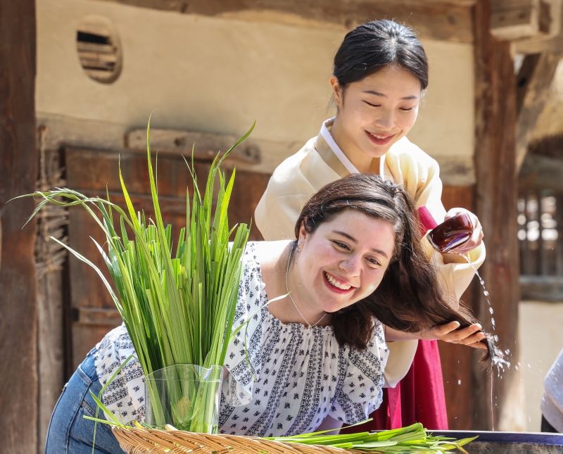 6月2日上午端午节前一天，在首尔钟路区国立民俗博物馆，一名外国人正在体验菖蒲水洗头。 