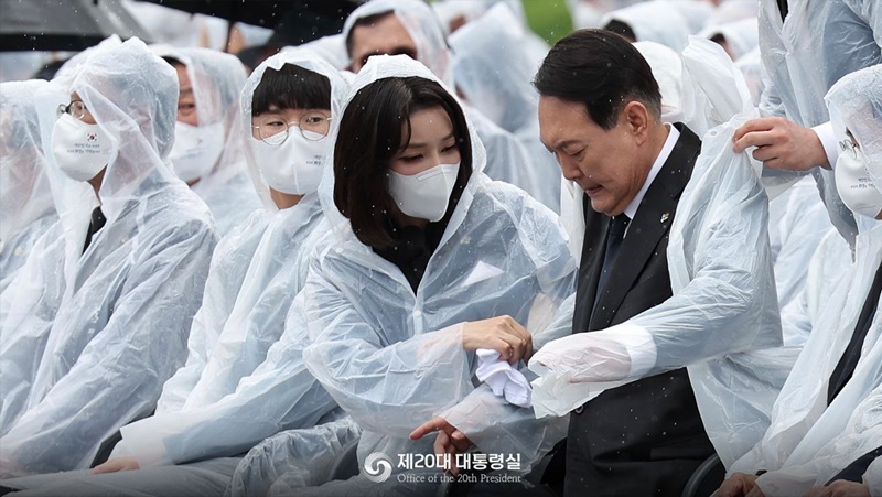 6月6日上午，第67届显忠日纪念仪式在首尔铜雀区的国立首尔显忠院举行。韩国总统尹锡悦夫人金建希拿出手帕为尹锡悦擦干被雨水淋湿的衣服。图片来源：韩国第20届总统室