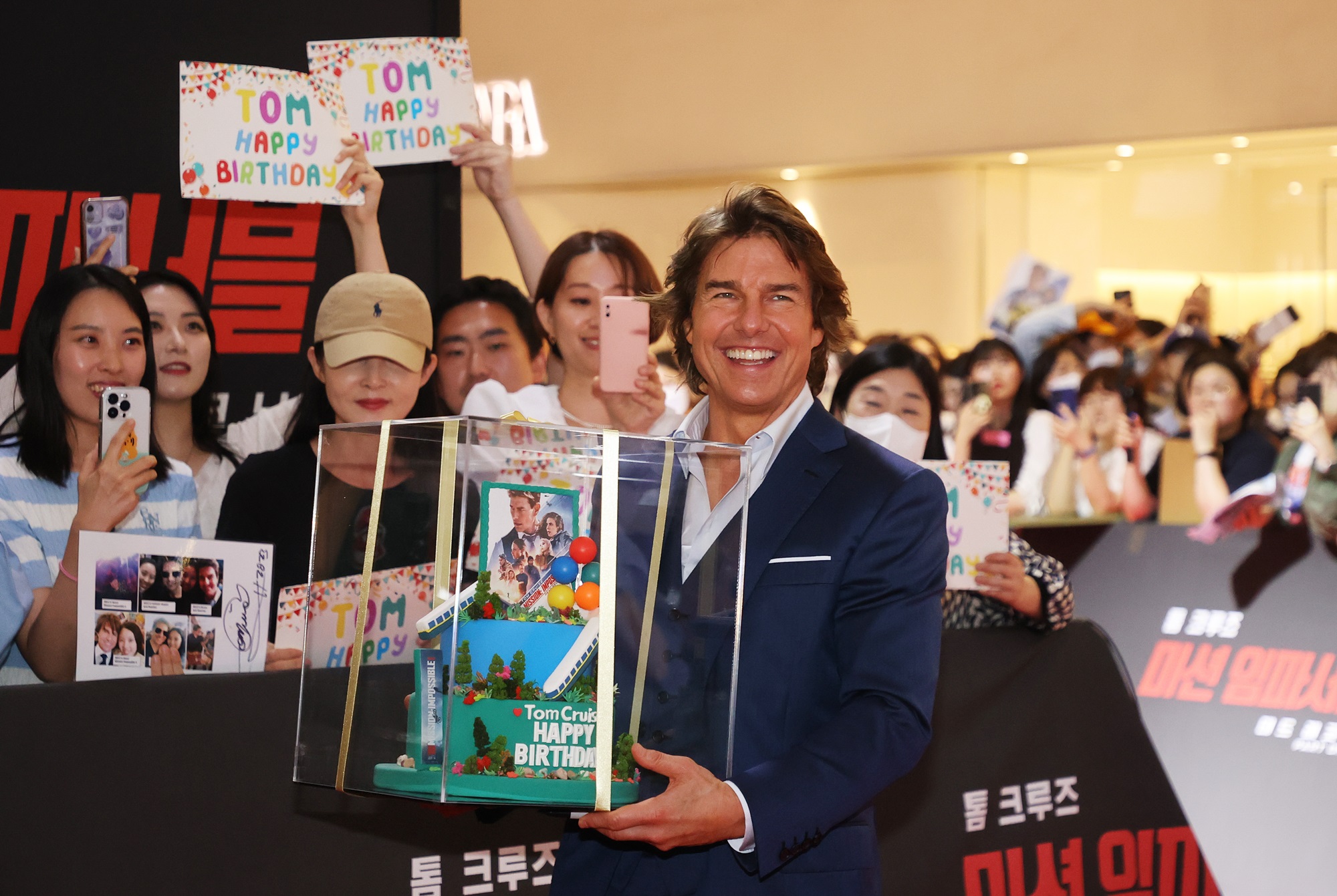 6月29日，在首尔松坡区乐天世界购物中心，凭借新片《碟中碟7：致命清算》来韩宣传的汤姆·克鲁斯在红毯上正在接受韩国粉丝的生日蛋糕。图片来源：韩联社