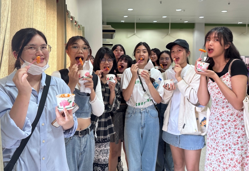 7月14日，在泰国马哈沙拉堪府的马哈沙拉堪大学里，学生们正在品尝韩国的辣炒年糕。