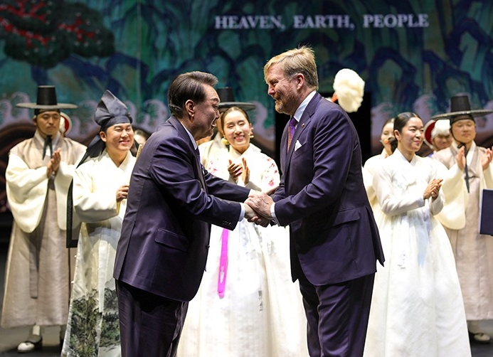 当地时间12月13日，在荷兰阿姆斯特丹AFAS Live音乐厅举办的国事访问答谢文化活动——“韩国传统音乐与舞蹈”上，韩国总统尹锡悦（左）与荷兰国王威廉·亚历山大一同登台并相互握手。大韩民国总统室申有憼 摄