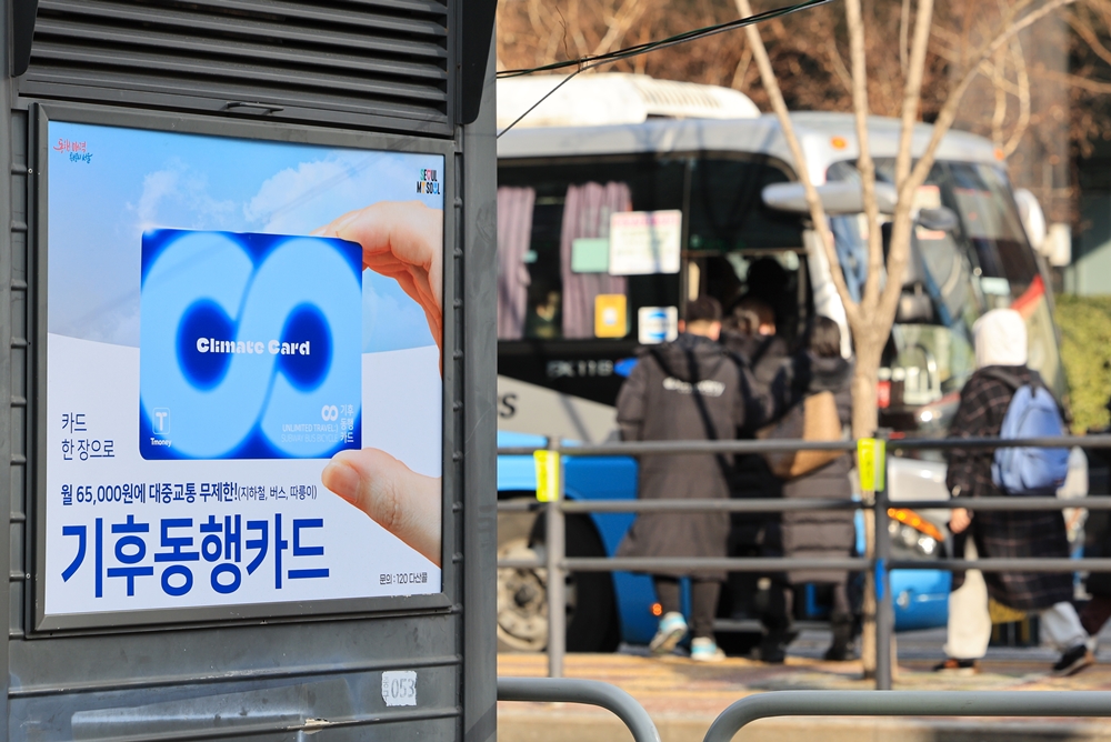 1月22日，在首尔市内公交车站附近，贴着一张宣传首尔市公交一卡通月卡“气候同行卡”的广告牌。图片来源：韩联社