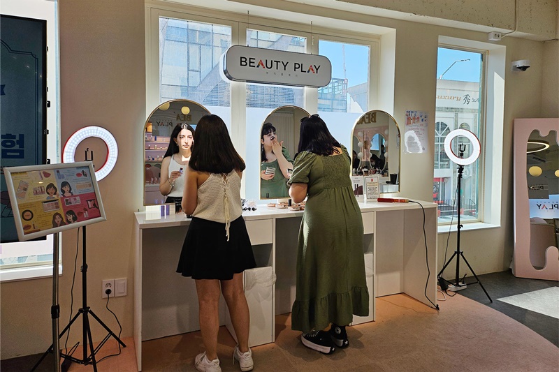 来自土耳其的迪拉克·雅普兹（右）在接受眼部化妆后，和朋友在“Beauty Play”弘大店三楼自助化妆区，正在完成剩下的妆容。 韩宣网记者Cao Thi Ha 摄