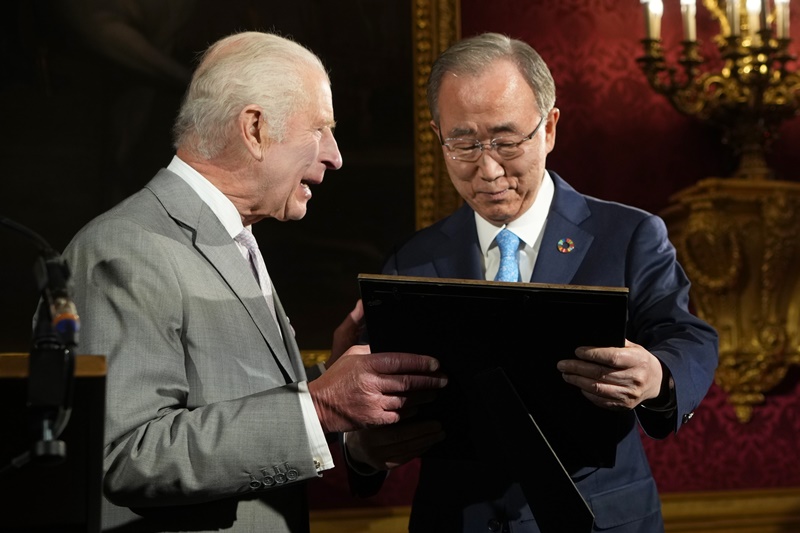 当地时间11日，在英国伦敦圣詹姆斯宫，联合国前秘书长潘基文（右）正在捧着奖牌与英国国王查尔斯三世笑谈。图片来源：韩联社 