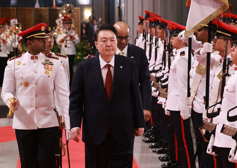 当地时间10月8日上午，在新加坡议会举行的欢迎仪式上，韩国总统尹锡悦与新加坡总统尚达曼一同检阅仪仗队。图片来源：韩联社 