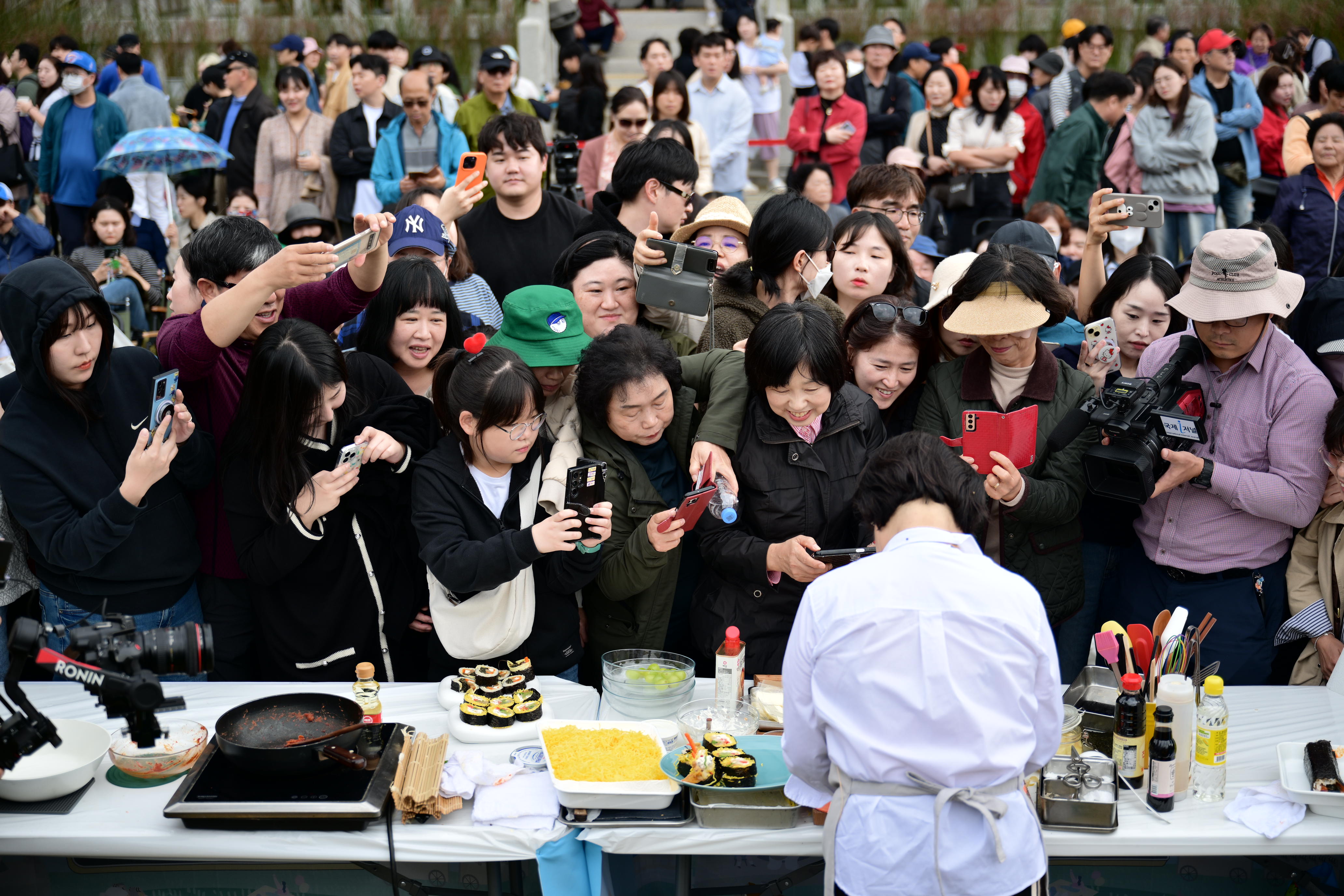 10月26日，来到“金泉紫菜包饭庆典”的访客们正在拍摄美食专家李惠贞（音）准备紫菜包饭的场面。图片来源：金泉紫菜包饭庆典组委会