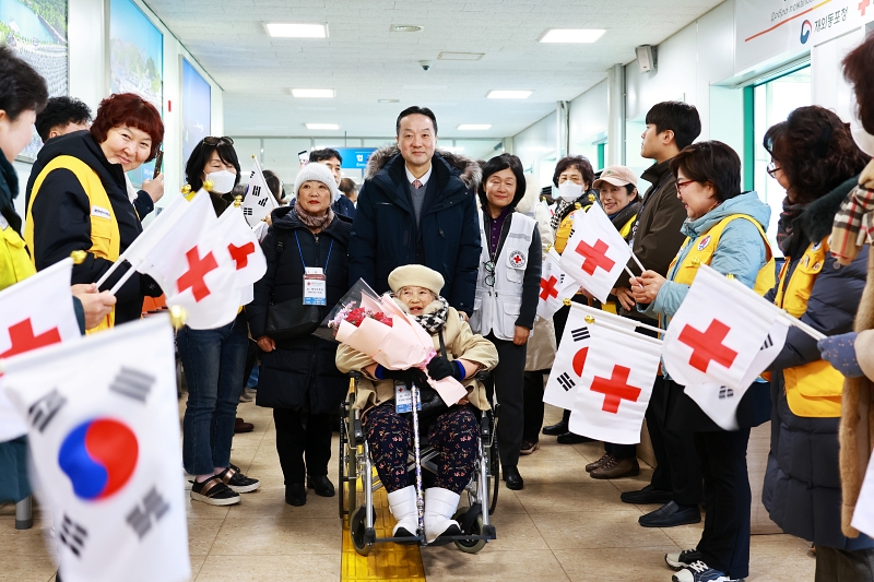 2月9日，在江原道东海港国际客运码头，韩国在外同胞厅次长卞哲桓（音）推着此次集体入境的萨哈林同胞中最高龄者崔君子（92岁）的轮椅，前往欢迎仪式现场。图片来源：在外同胞厅