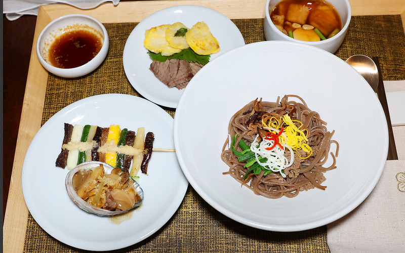 '在“皇帝的餐桌”上再现的美食。从右下角开始，顺时针方向依次是骨董面、酱烧鲍鱼、华阳串、醋酱、香煎油鱼、白切肉和酱辛奇。韩宣网记者李廷佑 摄