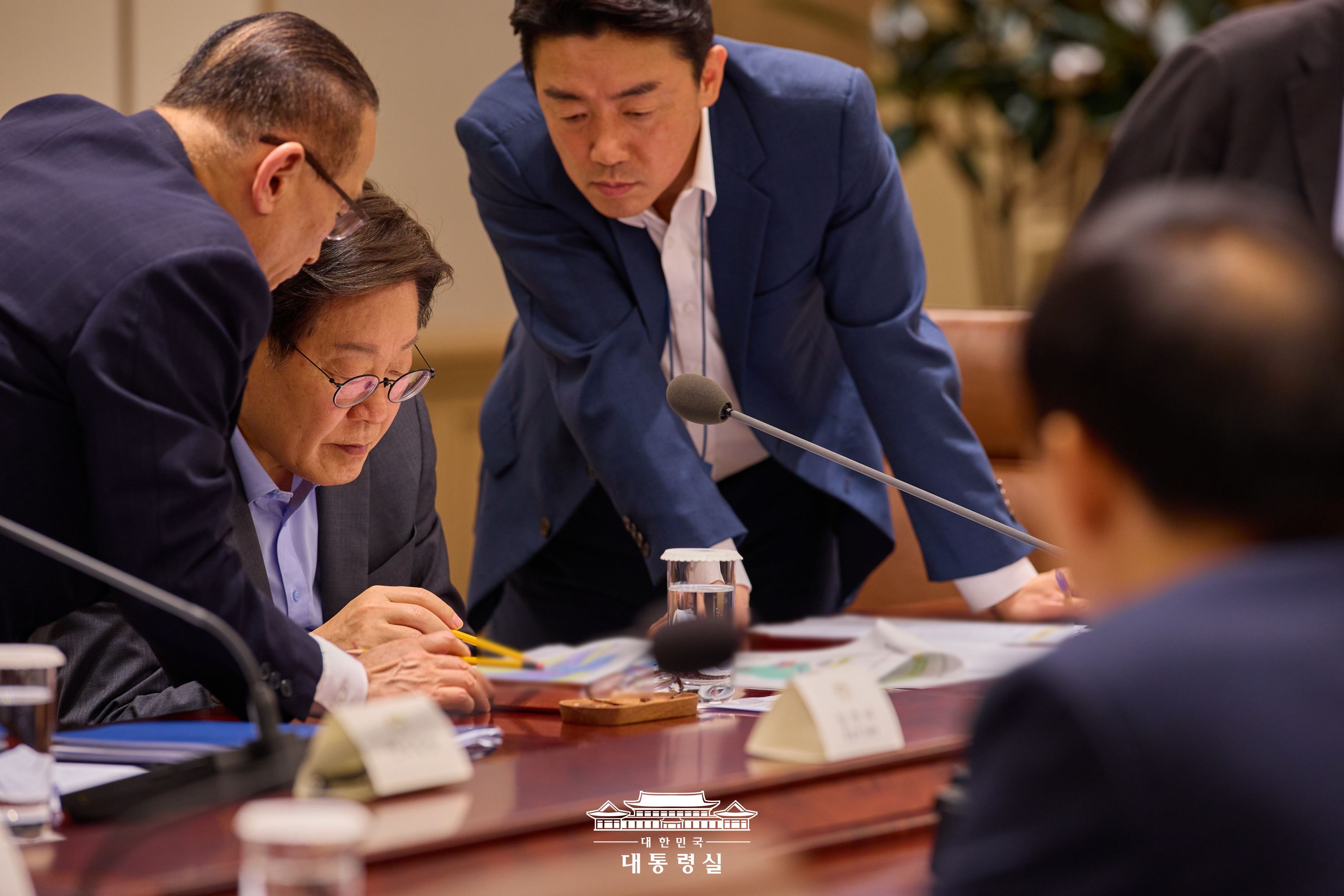 7月10日，韩国总统李在明（左二）出席在首尔龙山总统室举行的国家安全保障会议（NSC）全体会议，与国家安保室长魏圣洛、总统秘书室长姜勋植正在探讨国家安全相关问题。图片来源：大韩民国总统室