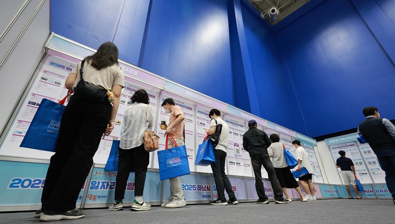 图为7月11日，在“2025河南市就业博览会”上，求职者正在查看招聘公告。图片来源：韩联社