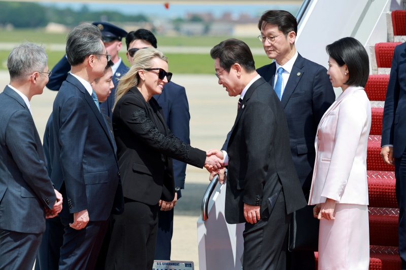 当地时间8月24日，韩国总统李在明与夫人金惠景抵达美国华盛顿郊外的安德鲁斯联合基地，并与前来迎接的美国礼宾司副司长艾比·琼斯握手致以。图片来源：韩联社