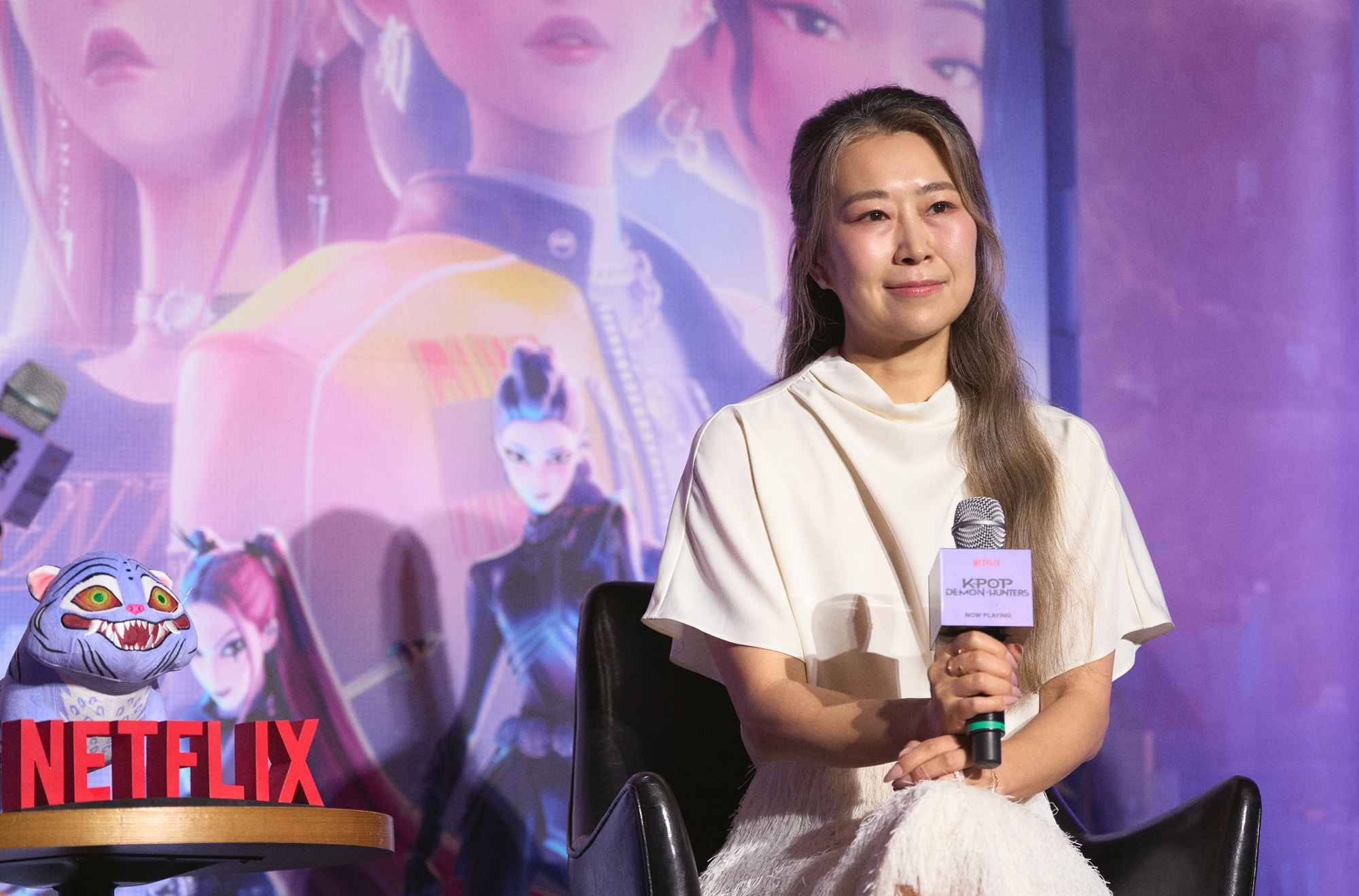 8月22日，在首尔CGV星聚汇影城龙山爱宝客商城店举行的奈飞（Netflix）动画片《K-POP：猎魔女团》记者招待会上，来韩的该片导演玛吉·康正在听取记者的提问。图片来源：奈飞