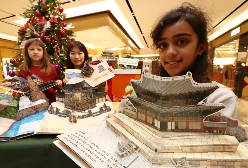 手持韩国世界文化遗产立体书的外国儿童。图片来源：韩联社