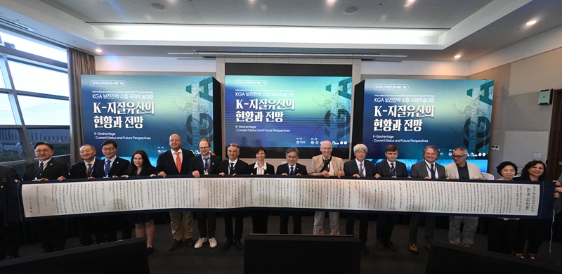 5月27日，在釜山BEXCO举行的核心地质遗产地区（KGA）保护战略国际学术大会现场，与会者举起写有KGA《韩国宣言》的9米韩纸装裱作品。图片来源：国家遗产厅