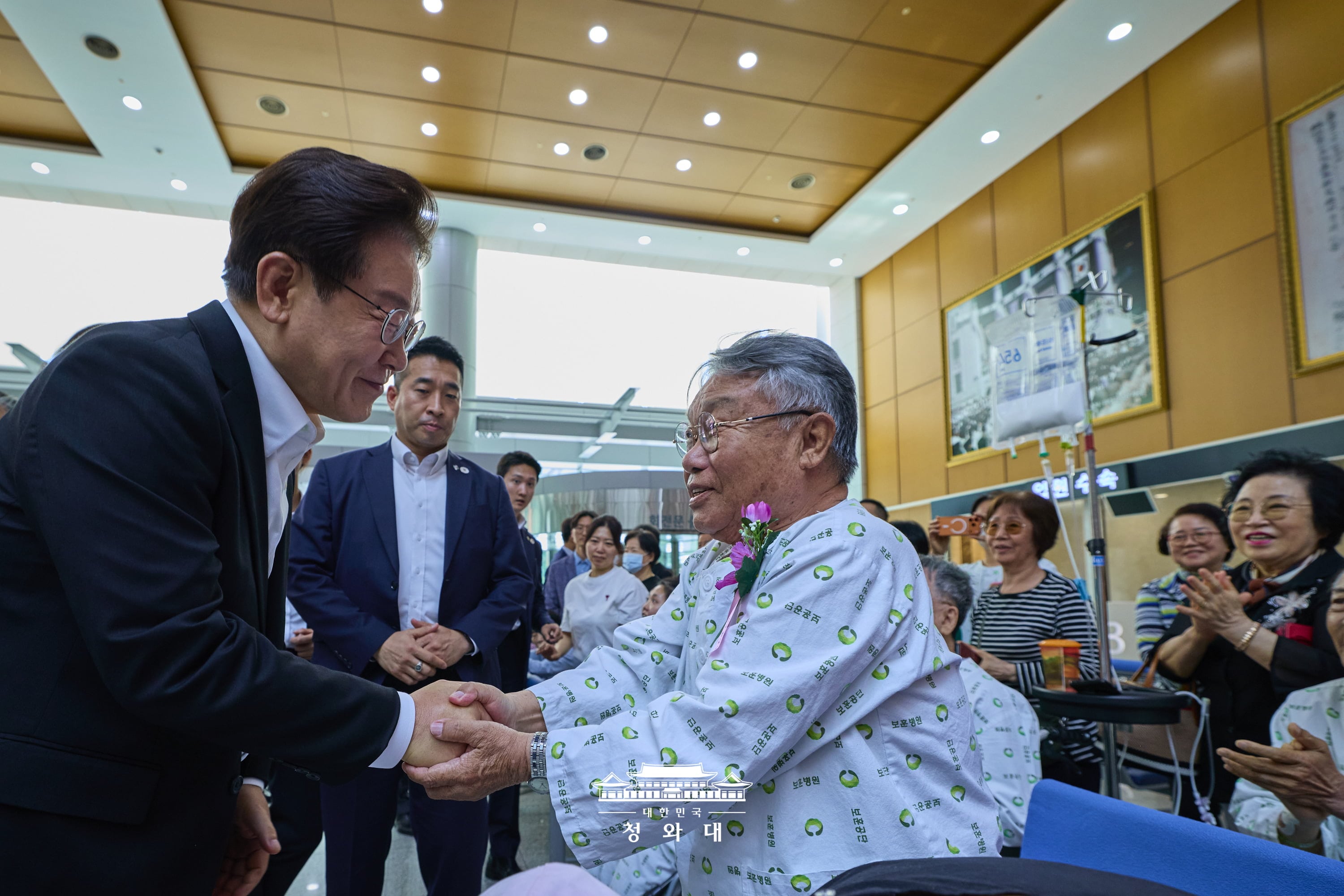 图为6月6日显忠日当天，韩国总统李在明（左）前往首尔江东区的中央报勋医院，慰问国家有功人士。图片来源：大韩民国青瓦台