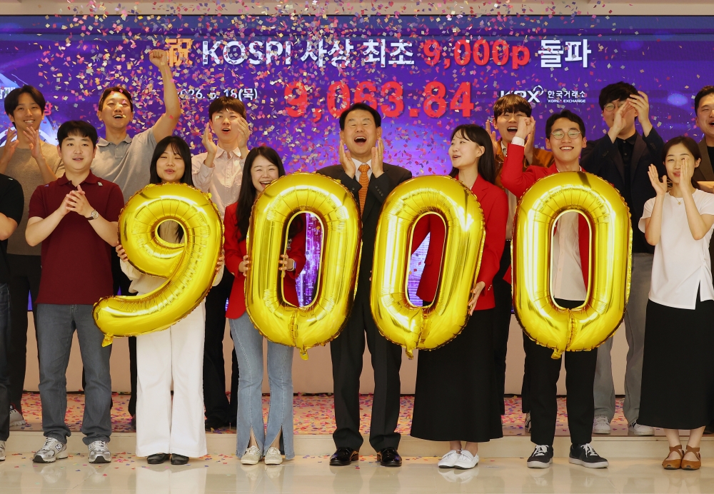 6月18日，韩国综合股价指数（KOSPI）首次突破9000点。图为工作人员在釜山南区韩国交易所总部宣传馆举行庆祝活动。图片来源：韩联社