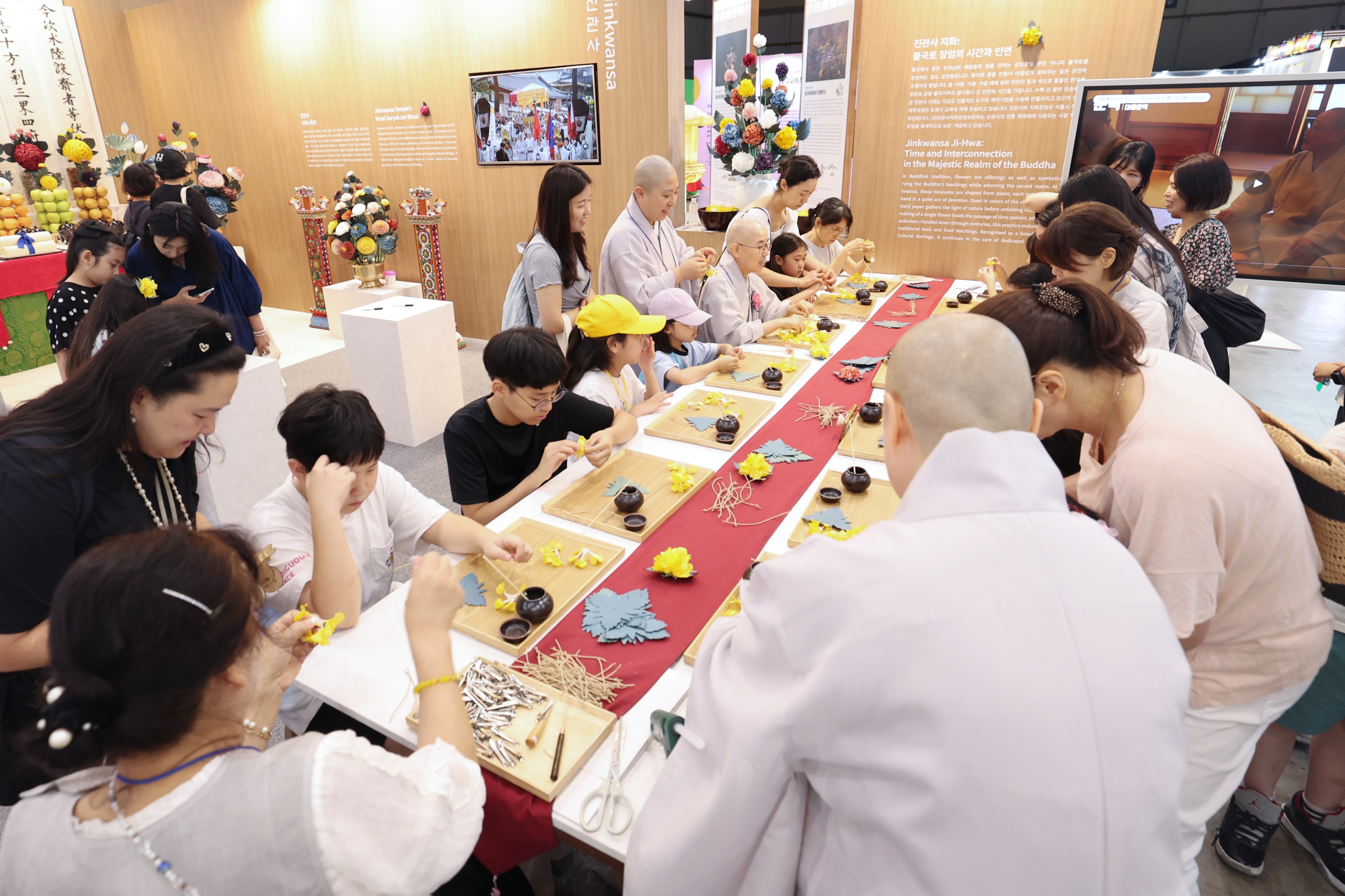 7月23日，一名来访者在釜山BEXCO韩国馆津宽寺展位正体验制作韩国传统“纸花”。韩宣网记者朴大珍 摄