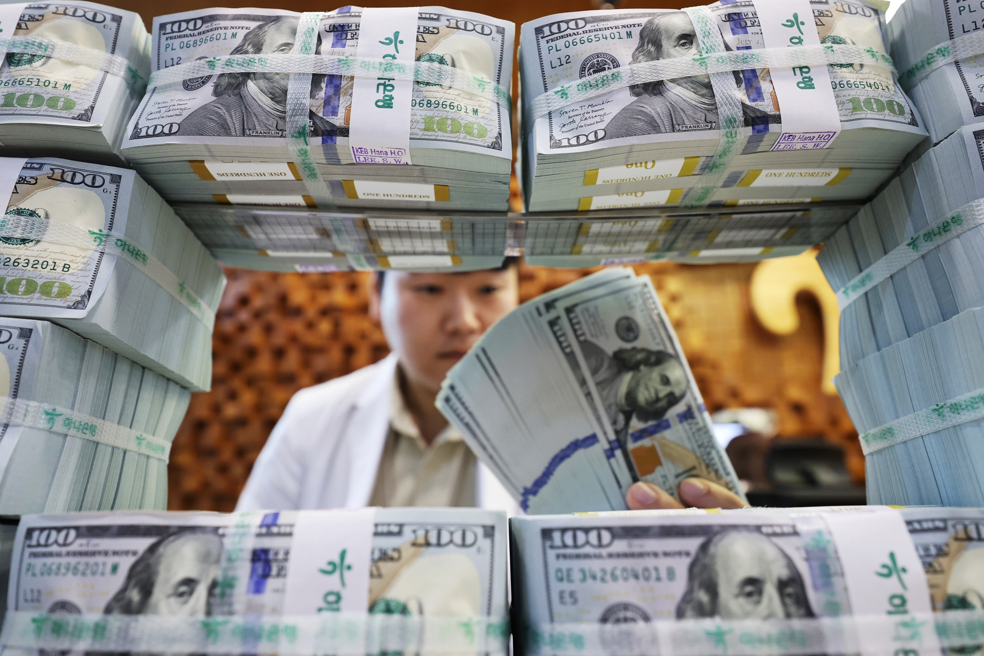 8月5日，韩国银行方面表示，受新发行外汇平准基金债券等因素带动，韩国7月外汇储备连续两个月实现增长。图为当天，在首尔市中区韩亚银行防伪应对中心，工作人员整理外币。图片来源：韩联社