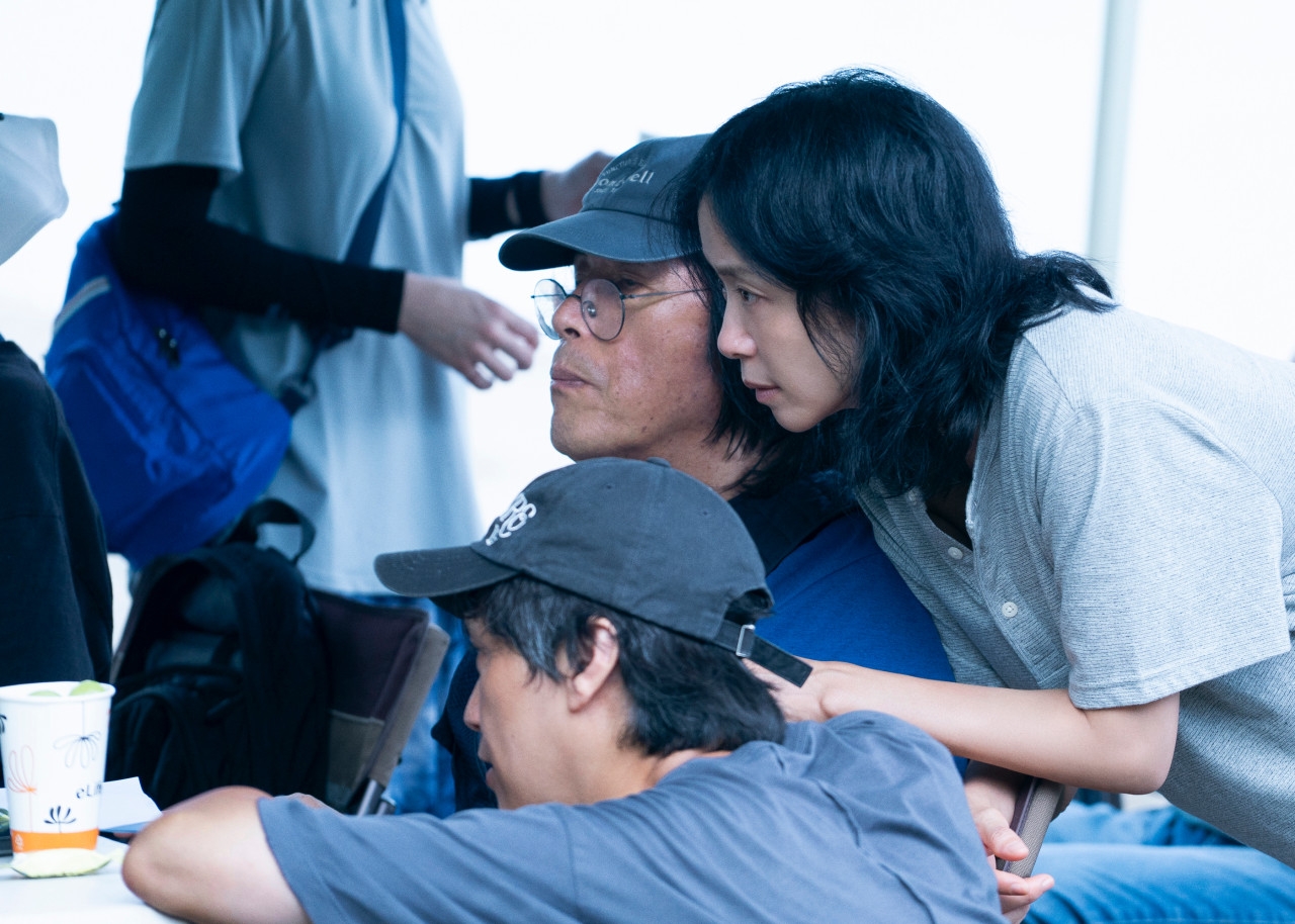 图为李沧东导演（中）在电影《可能的爱情》片场。图片来源：奈飞
