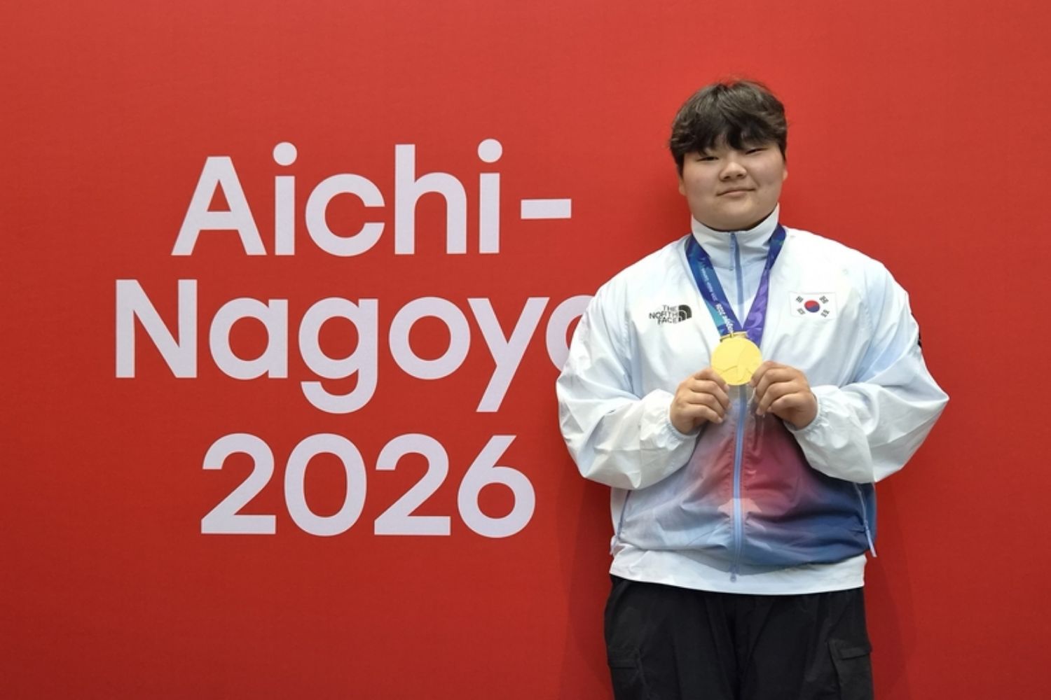 9月29日，在日本爱知县武道馆举行的2026爱知&middot;名古屋亚运会克柔术女子87公斤以上级比赛中，夺冠的韩国选手金敏英举起金牌。图片来源：韩联社