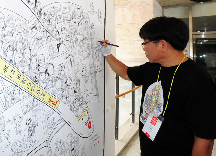 안중걸 작가가 부천국제만화축제 행사장에 기념 벽화를 그리고 있다.