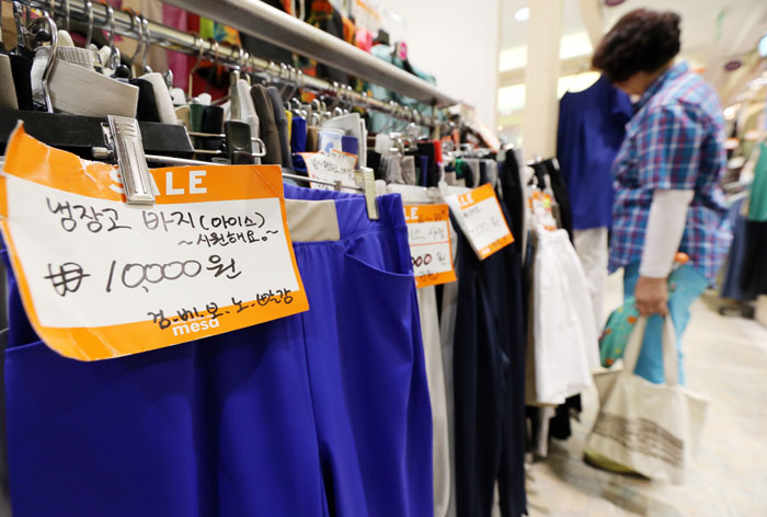 서울 남대문 시장에서 손님들이 상점에 진열된 ‘냉장고 바지’를 고르고 있다. ‘냉장고 바지’는 반바지부터 정장 스타일의 긴 바지까지 취향에 따라 선택할 수 있다.