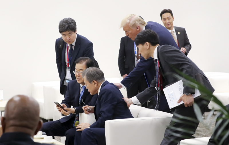 6月29日，韩国总统文在寅在日本大阪国际会展中心，与韩国国家安保室长郑义溶正在交谈。当时，美美国总统唐纳德•特朗普走过来问道，是否看到本人对朝鲜国务委员长金正恩发出会面邀请的推特发文。图片来源：韩联社