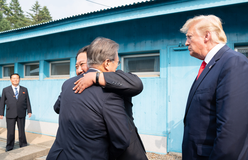 6月30日，在美国总统唐纳德•特朗普的注视下，韩国总统文在寅和朝鲜国务委员长金正恩在板门店军事分界线前相互拥抱。图片来源：美国白宫