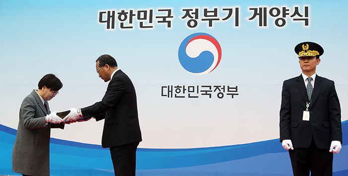 대한민국 정부기 게양식이 열린 29일 홍윤식 행정자치부 장관이 지난 67년간 사용된 ‘무궁화’ 문양의 구형 정부기를 국가기록원에 이관하고 있다. 