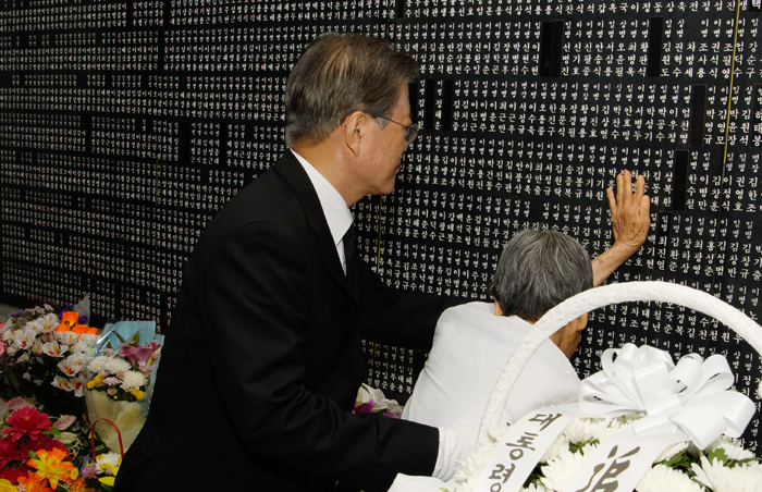 문재인 대통령이 6일 국립서울현충원 현충탑 아래 위패봉안관에서 김차희 여사(93)를 부축하고 있다. 김차희 여사는 학도병 신분으로 한국전쟁에 참전했다 전사한 고(故) 성복환 일병의 아내다.