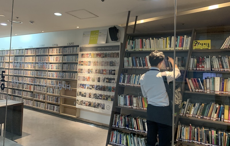 在地铁站的玻璃房内，一位市民正在挑选DVD。图片来源：忠武路影像中心oh!zemidong