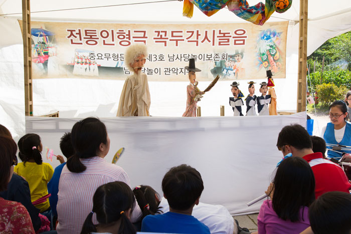 어린이들이 국립민속박물관에서 풍년을 축하하는 내용의 꼭두각시놀이를 관람하고 있다.