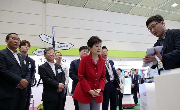 在政府3.0国民体验场上，朴总统正在听取关于利用公共数据搜索停车场的应用程序的说明。