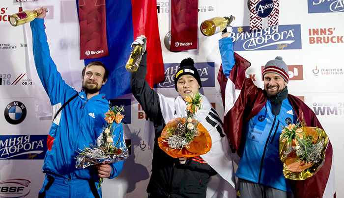 20日在奥地利因斯布鲁克召开的2016俯式冰橇世界锦标赛大赛领奖台上，尹成斌挂着银牌欢呼。照片从左至右，并列亚军的特列季亚科夫（俄罗斯）、尹成斌、冠军Martins Dukurs（拉脱维亚）。