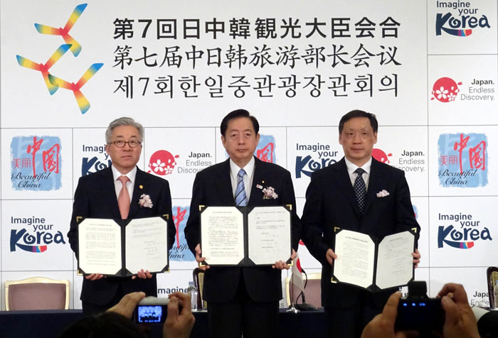 12일 도쿄에서 열린 한-일-중 관광장관 회의에서 3국은 상호 인적교류 규모를 2020년까지 3천만 명으로 늘리는 목표 등을 담은 공동성명을 발표했다. 사진은 공동성명을 체결하고 손을 맞잡은 김종덕 문화체육관광부 장관(왼쪽)과 오타 아키히로 일본 국토교통상(가운데), 리진자오 중국 국가여유국장(오른쪽). 