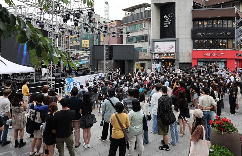 6月27日，据首尔市公布的《首尔市外国人生活人口分布》调查结果显示，白天最多在新村地区活动。图为19日，在西大门区新村延世路一带，市民们正在观看街头演出。图片来源：西大门区厅