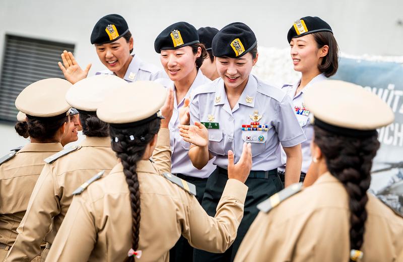 当地时间6月29日，在奥地利古兴市举行的第45届国际军体跳伞世界锦标赛（WMPC）上，获得四人造型跳伞金牌的韩国特种部队女兵正在与排名第二的摩洛哥队击掌祝贺。图片来源：第45届国际军体跳伞世界锦标赛官网