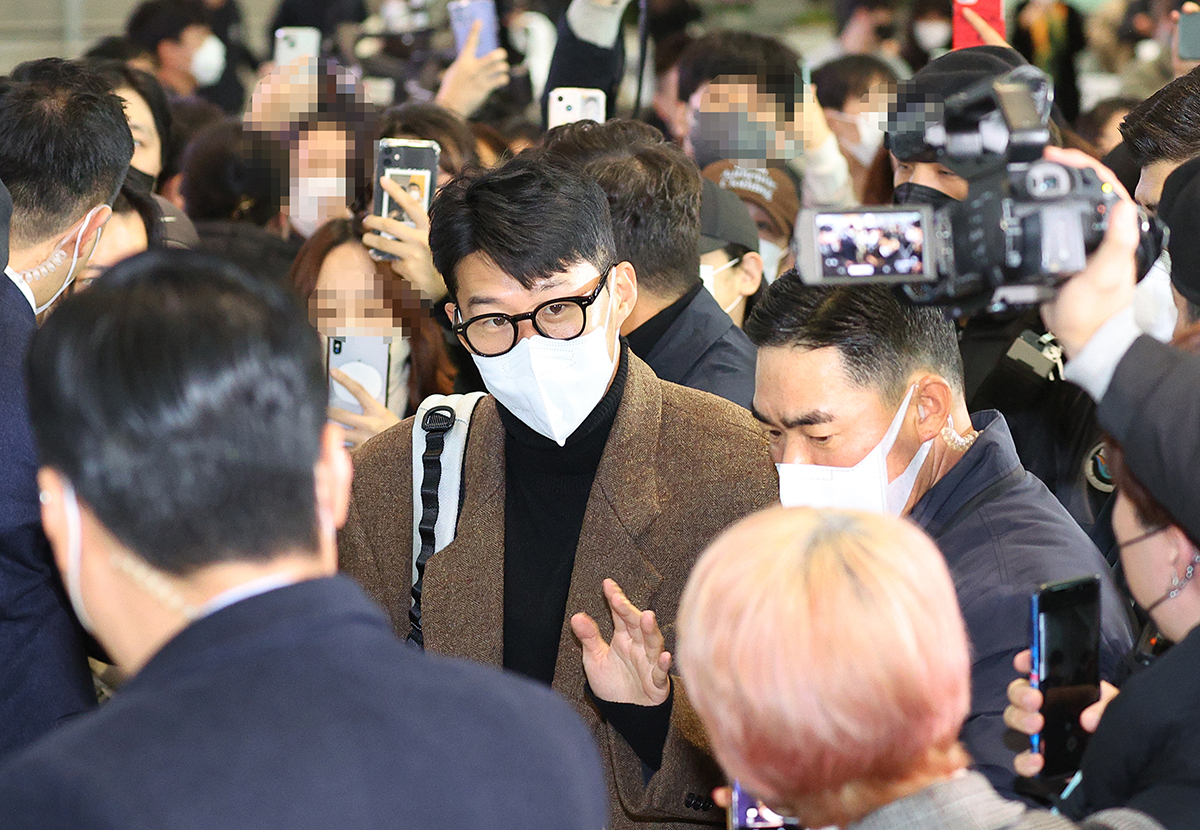 12月13日上午，在仁川国际机场第二航站楼，韩国国家足球队队长孙兴慜乘机前向前来送行的球迷们挥手致意。