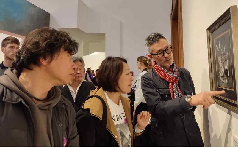 当地时间3月31日，位于匈牙利布达佩斯驻匈牙利韩国文化院企划展览室举办的布达佩斯摄影节开幕典礼上策展人与摄影家们正在观赏展览作品。“韩国当代摄影展：深入了解自然与人”特别受邀于布达佩斯摄影节“K-session”环节。