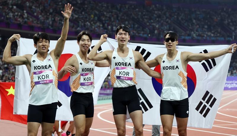 10月3日，在中国杭州奥体中心体育场举办的田径项目男子4x100米接力决赛上，获得铜牌的韩国选手展开太极旗欢呼。从左依次为金局颍、李廷泰、李在晟、高承焕。图片来源：韩联社
