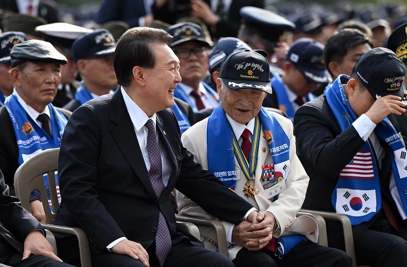 10月12日，在首尔龙山战争纪念馆和平广场，出席长津湖战役第73周年纪念仪式的尹锡悦（左）正在紧握着曾参加1950年兴南港大撤退的参战勇士金英善（音）的双手。大韩民国总统室金容𬀩 摄