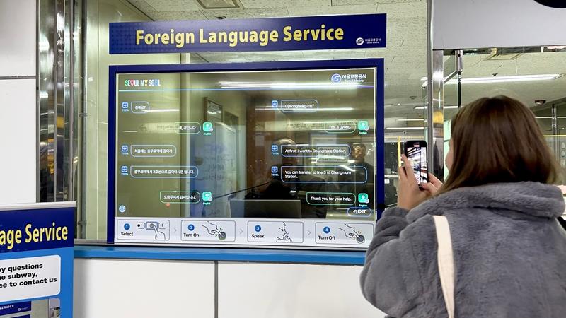 12月12日，来自土耳其的游客卡德伦·科斯，正在明洞站内的“外国语同时对话系统”前进行拍摄。韩宣网记者崔珍瑀 摄