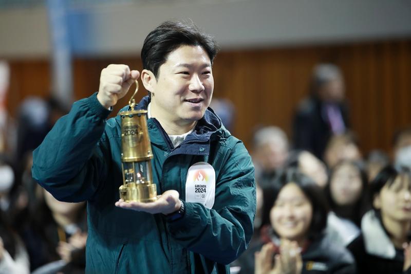 11月28日，在江原道原州市育民馆高中举办的“2024年江原冬季青年奥林匹克运动会圣火传递”活动上，秦钟午正在传递圣火。图片来源：韩联社